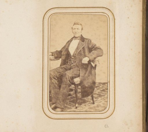 Portrait of a seated man with a photo album