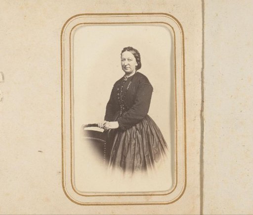 Portrait of a woman standing by a chair