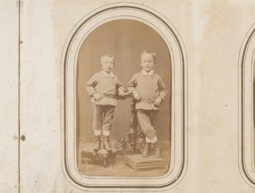 Portrait of two boys standing by a table