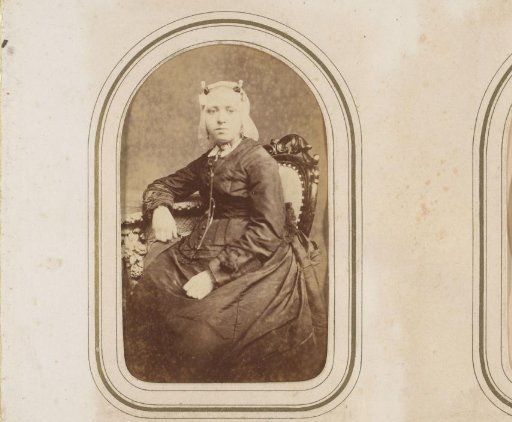 Portrait of a seated girl in a white traditional cap and ear protectors