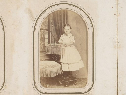 Portrait of a girl in a white dress, standing by a chair