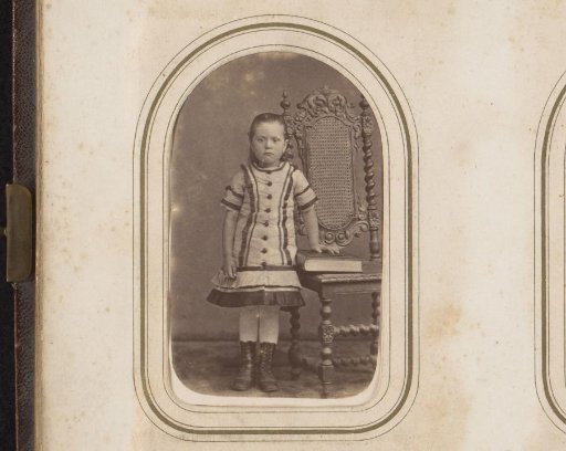 Portrait of a girl standing by a chair with a book