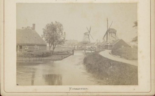 View of a canal with mills, buildings and people in Wormerveer