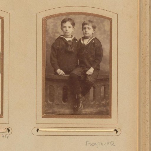 Portrait of two boys in sailor suits, sitting on a balustrade