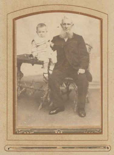 Portrait of a sitting bearded man and a boy sitting on a table