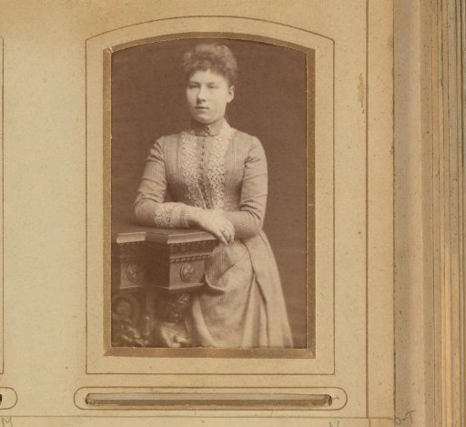 Portrait of a young woman, leaning on a piece of furniture