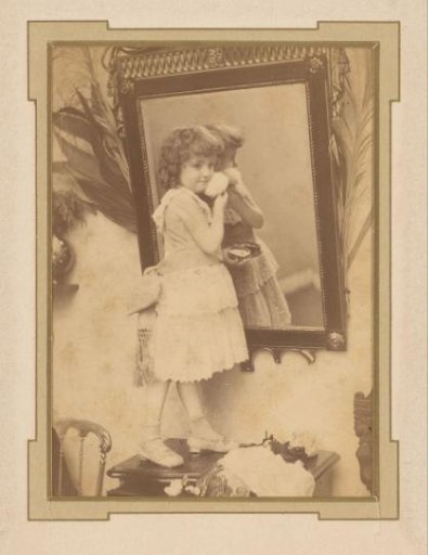 Portrait of a standing girl with a powder box before a mirror