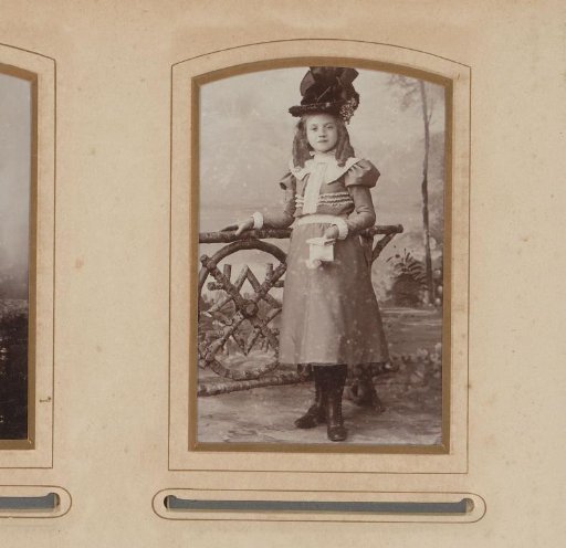 Portrait of a standing girl with a hat and a book in her hand