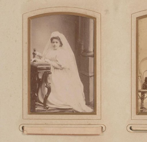Portrait of a girl in a communion dress, kneeling on a prayer stool