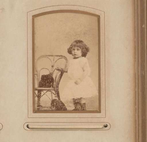 Portrait of a girl, standing by a chair