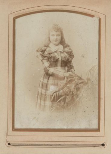 Portrait of a girl, standing beside a plant