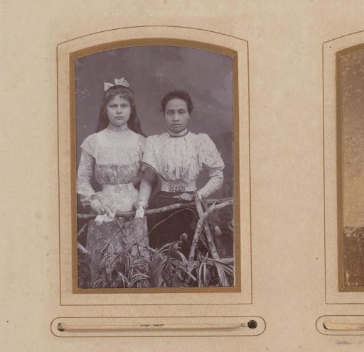 Portrait of two girls, standing by a fence