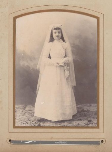 Portrait of a standing girl in a communion dress