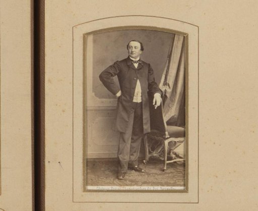 Portrait of a man standing by a chair