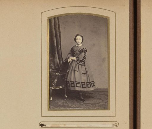 Portrait of a girl standing by a chair