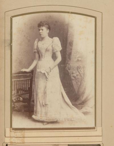 Portrait of a woman standing by a chair
