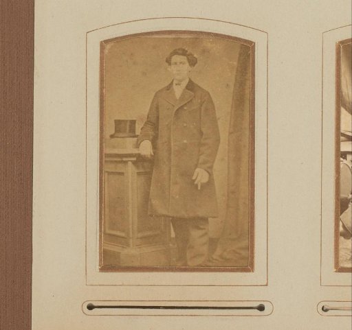 Portrait of a man in a coat, standing by a pillar with a tall hat