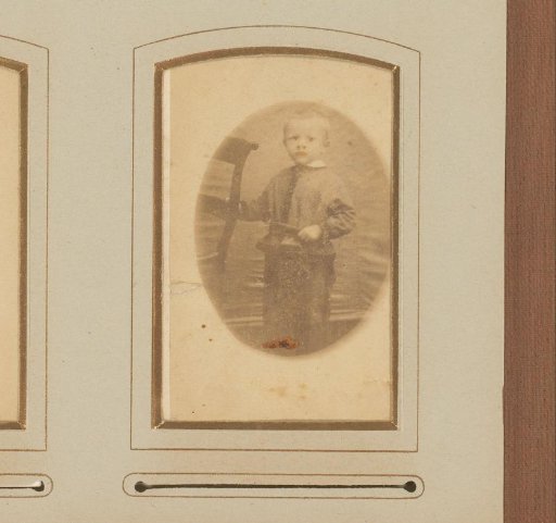 Portrait of a boy, standing by a chair