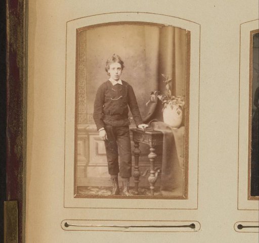 Portrait of a boy, standing by a table