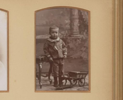 Portrait of a Standing Boy in a Sailor Suit with a Toy Horse and Cart