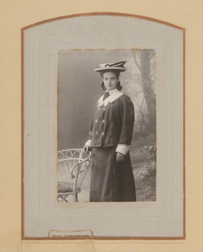 Portrait of a Young Woman with a Hat, Standing by a Chair