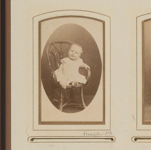Portrait of a baby, seated in a wicker chair