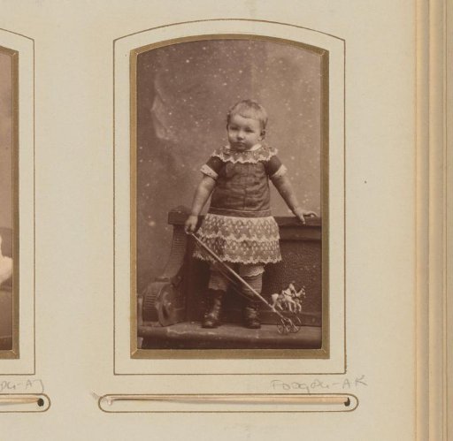 Portrait of a standing girl with a toy in hand