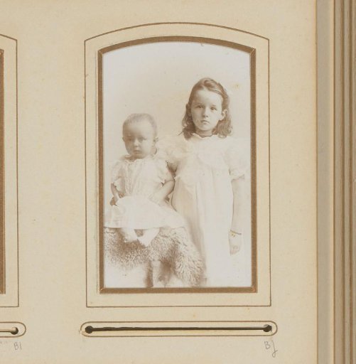 Portrait of a seated baby and a standing girl