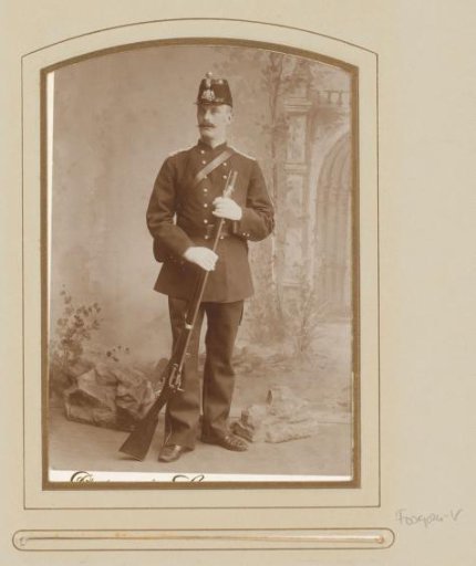 Portrait of a standing man in military uniform with a musket in hand