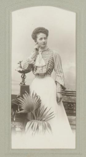 Portrait of an unknown woman by a houseplant