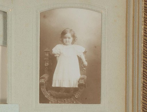 Portrait of an unknown child standing on a chair