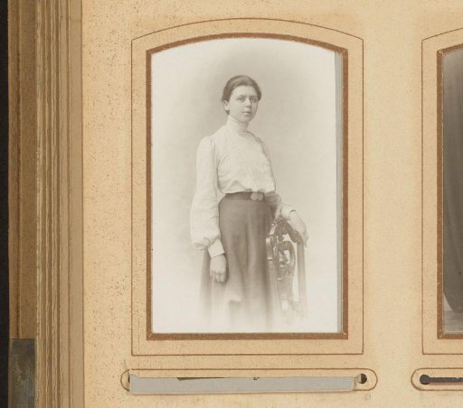 Portrait of a young woman, standing by a chair
