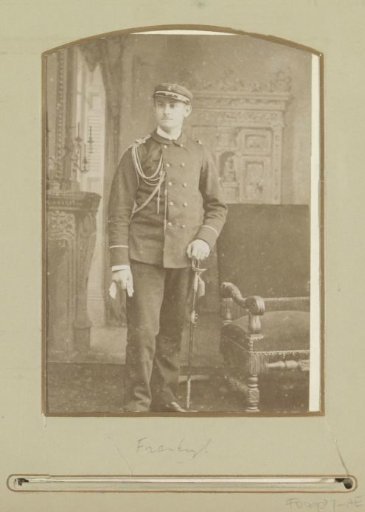 Portrait of a (presumably) French soldier, standing by an armchair with a sabre