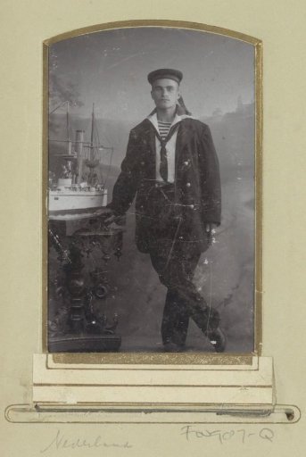 Portrait of a (presumably) Dutch sailor, standing by a ship model on a table