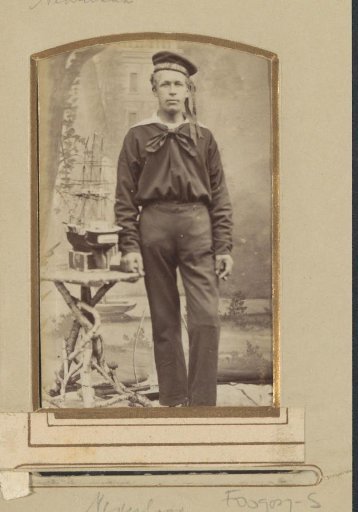 Portrait of a sailor of the Royal Navy, standing by a ship model on a table