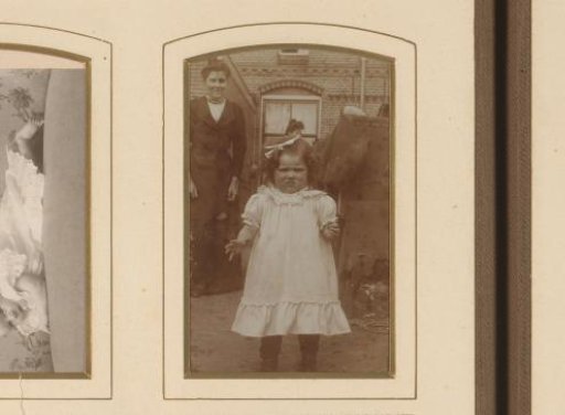 Portrait of a standing girl in a garden with two women in the background