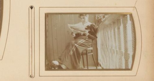 Woman on a chair on a balcony, with newspaper in hand