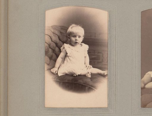 Portrait of a sitting child in a white dress