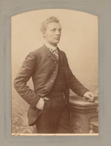Portrait of a man standing by a pillar