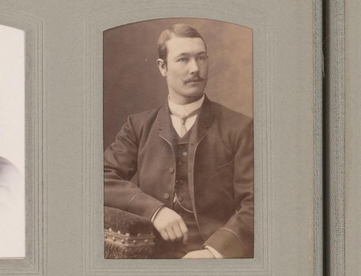 Portrait of a seated man with a moustache