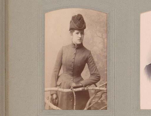 Portrait of a Woman with Gloves and a Hat, Standing by a Fence