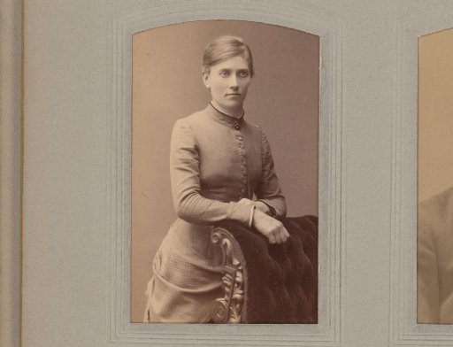 Portrait of a Standing Young Woman Leaning on the Arm of an Armchair