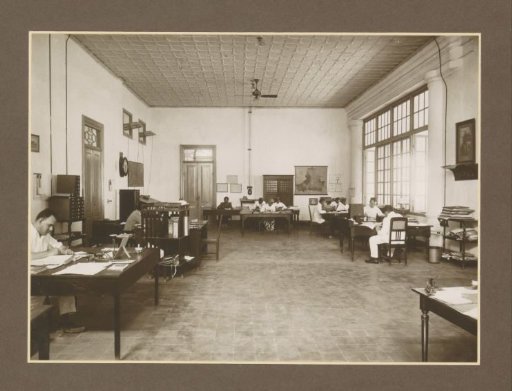 Office interior with clerks and furniture of the Meritjan sugar factory in Kediri, Java