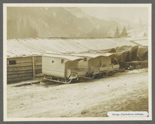 Barracks with parked ambulance sleds, one has a red cross