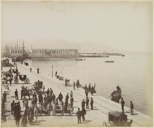 Quay with crates of bottles, carriages, tram rails, sailors and onlookers in Smyrna