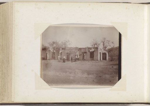 Women and a man posing in front of a destroyed house in South Africa