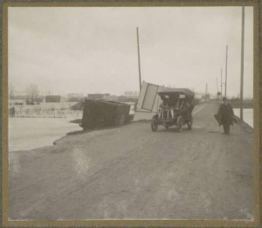 Car and a pedestrian on a road amidst water in a suburb of Paris