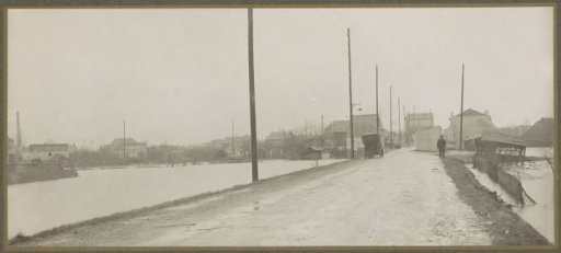 Panoramic photograph of a car and a photographer on a road amidst water in a suburb of Paris
