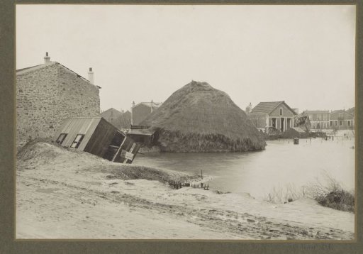 Collapsed haystack and destroyed barns and houses in a flooded suburb of Paris