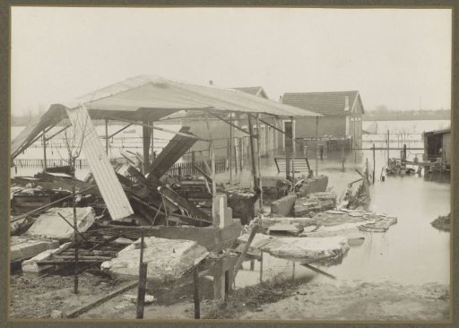 Destroyed barn and a house in a flooded suburb of Paris